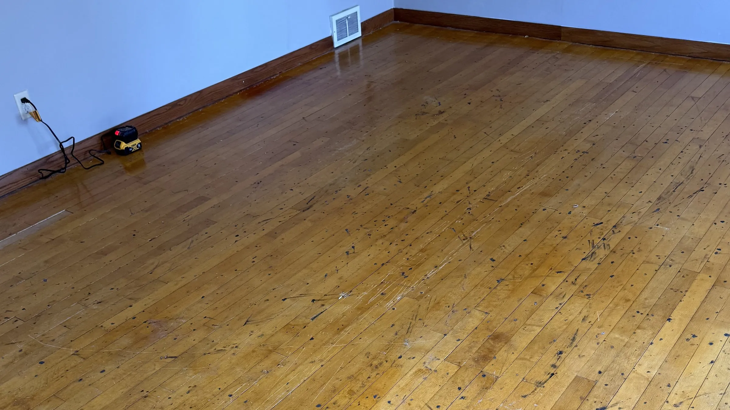 Before — worn hardwood floor in need of refinishing