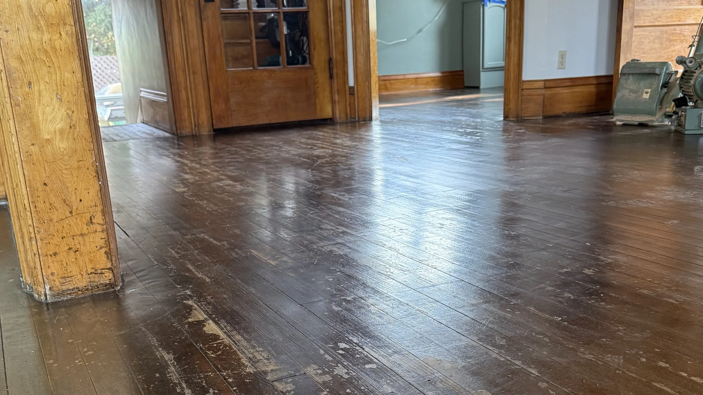 Before — worn hardwood floor in need of refinishing